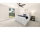 Bright bedroom featuring a ceiling fan, neutral walls, and a large window showcasing the lush backyard at 6121 38Th W Ave, Bradenton, FL 34209