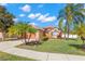 Exterior of single Gathering home, showcasing the manicured lawn, mature palm trees, and attached two-car garage at 6426 Gondola Dr, Riverview, FL 33578