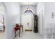 Light-filled foyer featuring tile floors, decorative lighting, grand clock, and a large arched window above the double entry door at 6426 Gondola Dr, Riverview, FL 33578