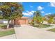 Exterior view of a single Gathering home with a two-car garage, lush lawn, and mature trees, and long driveway at 6426 Gondola Dr, Riverview, FL 33578