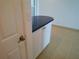 Hallway with blue countertop, tile flooring, white walls, and a door at 7000 Beach Plz # 805, St Pete Beach, FL 33706