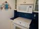 Updated kitchen with white appliances, blue backsplash, and white cabinets at 7000 Beach Plz # 805, St Pete Beach, FL 33706