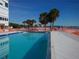 Community swimming pool area surrounded by palm trees and a pool deck at 7000 Beach Plz # 805, St Pete Beach, FL 33706