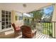 Relaxing balcony with wicker chairs and views of mature trees at 7300 Sunshine Skyway S Ln # 202, St Petersburg, FL 33711