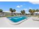 Community pool with lounge chairs surrounded by tropical palm trees and buildings at 7300 Sunshine Skyway S Ln # 202, St Petersburg, FL 33711