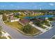 A neighborhood's aerial view, showcasing houses along a lake, near green spaces, and a water tower at 7304 63Rd E Ct, Palmetto, FL 34221