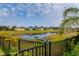 Scenic backyard with a pond view, complemented by a black fence and lush vegetation at 7304 63Rd E Ct, Palmetto, FL 34221