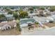 Aerial view of the property, showcasing its green roof, expansive driveway, and neighborhood setting at 9121 Prosperity Ln, Port Richey, FL 34668