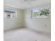 Bright bedroom featuring two windows and a ceiling fan at 9121 Prosperity Ln, Port Richey, FL 34668