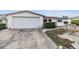 Long driveway leading to a one story home with attached garage at 9121 Prosperity Ln, Port Richey, FL 34668