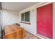 Welcoming front entrance features a bright red door, a sliding window, and unique tiled flooring at 9121 Prosperity Ln, Port Richey, FL 34668