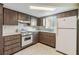 The kitchen features wooden cabinets, light countertops, and a white refrigerator, offering a practical cooking space at 9121 Prosperity Ln, Port Richey, FL 34668