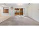 Bright living room with carpet floors and sliding glass doors leading to outdoor area at 9121 Prosperity Ln, Port Richey, FL 34668