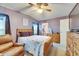 Bedroom with a wood frame bed, ceiling fan, and a view into the bathroom at 9417 Star Gazer Ln, Riverview, FL 33578