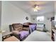 Bedroom with a comfy chair, ceiling fan, and natural light, creating a relaxing atmosphere at 9417 Star Gazer Ln, Riverview, FL 33578