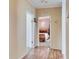 Hallway with wood-look floors leading to a bedroom with cozy decor and a warm ambiance at 9417 Star Gazer Ln, Riverview, FL 33578