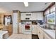 Well-lit kitchen equipped with white appliances and cabinetry, accented with backsplash at 9417 Star Gazer Ln, Riverview, FL 33578