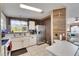 Well-equipped kitchen with stainless steel refrigerator and white appliances next to a dining bar at 9417 Star Gazer Ln, Riverview, FL 33578