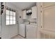 Bright laundry room with washer and dryer, white cabinets, and tiled floor at 9417 Star Gazer Ln, Riverview, FL 33578