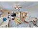 Inviting living room with a ceiling fan, modern entertainment center, and comfortable sofas at 9417 Star Gazer Ln, Riverview, FL 33578