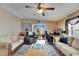 Spacious living room with a ceiling fan, comfortable seating, and a view of the screened-in patio at 9417 Star Gazer Ln, Riverview, FL 33578