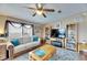 Bright living room featuring comfortable seating, a ceiling fan, and a stylish area rug at 9417 Star Gazer Ln, Riverview, FL 33578