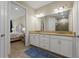 Bright bathroom with double sinks, neutral countertops and cabinetry, and doorway leading to bedroom at 11309 Callisia Dr, Odessa, FL 33556