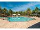 Resort-style community pool with palm trees, lounge chairs, cabanas, and orange umbrellas on a sunny day at 11309 Callisia Dr, Odessa, FL 33556