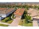Aerial view of house featuring a clay tile roof, landscaping, and brick driveway at 11309 Callisia Dr, Odessa, FL 33556