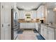 Well-lit kitchen with stainless steel appliances, tiled backsplash, white cabinets, and a window above the sink at 11309 Callisia Dr, Odessa, FL 33556