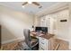 This home office has neutral paint, a modern ceiling fan, and an ensuite bathroom at 11309 Callisia Dr, Odessa, FL 33556