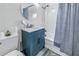 Cozy bathroom with blue vanity, round mirror, and shower with blue patterned curtain at 1155 23Rd N Ave, St Petersburg, FL 33704