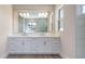 Elegant bathroom with double sink vanity, large mirror, and a separate glass-enclosed shower at 1201 Blue Shell Loop, Sarasota, FL 34240