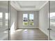 Bright bedroom with tray ceiling and recessed lighting offers tile floors and views of the front yard at 1201 Blue Shell Loop, Sarasota, FL 34240