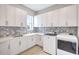 Bright laundry room boasts modern gray backsplash, neutral countertops, and front-loading washer and dryer at 1201 Blue Shell Loop, Sarasota, FL 34240