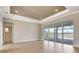 Bright living room with wood floors and sliding glass doors leading to the pool and lake at 1201 Blue Shell Loop, Sarasota, FL 34240