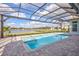 Screened-in pool and jacuzzi boast a view of the lake and neighboring homes at 1201 Blue Shell Loop, Sarasota, FL 34240