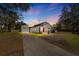 House exterior at sunset, showcasing a red door and detached garage at 1402 N Gordon St, Plant City, FL 33563