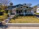 Charming craftsman style home with a lush front yard, front porch, and an American flag at 1405 Nance Ave, Tampa, FL 33606