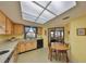 Sunlit kitchen with wood cabinetry and a breakfast nook adjacent to sliding glass doors at 1809 Atrium Dr, Sun City Center, FL 33573