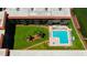 Overhead view of community pool and spa, surrounded by lush green lawns and palm trees at 19701 Gulf Blvd # 328, Indian Shores, FL 33785