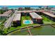 Aerial view of waterfront community featuring pool, docks, and lush landscaping at 19701 Gulf Blvd # 328, Indian Shores, FL 33785