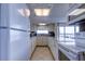 Well-lit kitchen with stainless steel appliances, white cabinets, and tile flooring at 19701 Gulf Blvd # 328, Indian Shores, FL 33785