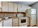 Bright kitchen featuring white appliances, upper cabinets, and laminate countertops at 19701 Gulf Blvd # 328, Indian Shores, FL 33785