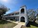 Attractive condo building featuring unique architecture, mature trees, and well-maintained landscaping at 2100 World Parkway Blvd # 56, Clearwater, FL 33763