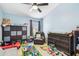 This bedroom has blue walls, a ceiling fan, and contains an assortment of toys at 2110 Wolfskill Pl, Riverview, FL 33578