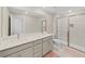 Elegant bathroom with dual vanities, a large mirror, and a walk-in shower at 2302 Village Amble Loop, Lutz, FL 33558