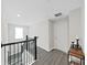 Upstairs hallway with gray flooring and a door to a bedroom at 2302 Village Amble Loop, Lutz, FL 33558