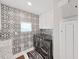 Functional laundry room with washer, dryer, and stylish black and white tile at 2302 Village Amble Loop, Lutz, FL 33558