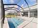 Inviting swimming pool with a screened enclosure and spacious patio at 2302 Village Amble Loop, Lutz, FL 33558